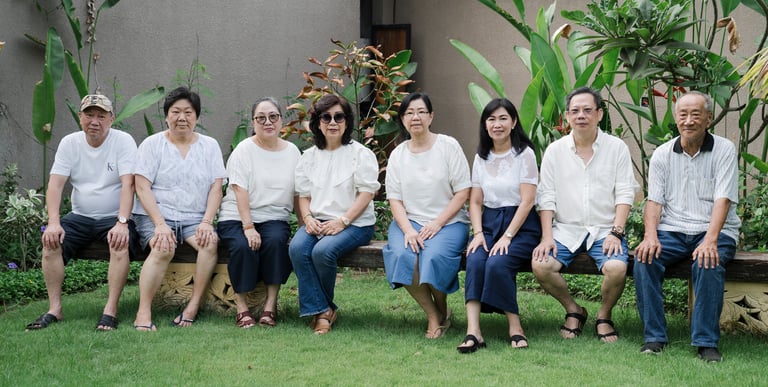 Multigenerational family seated in a row during extended family photography at Lumbini Villas Jimbaran Bali