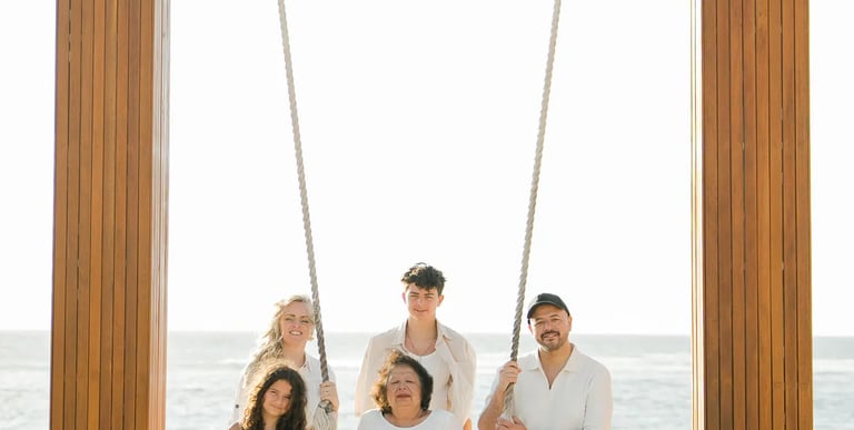 Parents embracing on the iconic beach swing at Ayodya Resort Bali in Nusa Dua