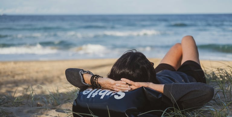 a young woman who has gone on holiday alone looks at the sea