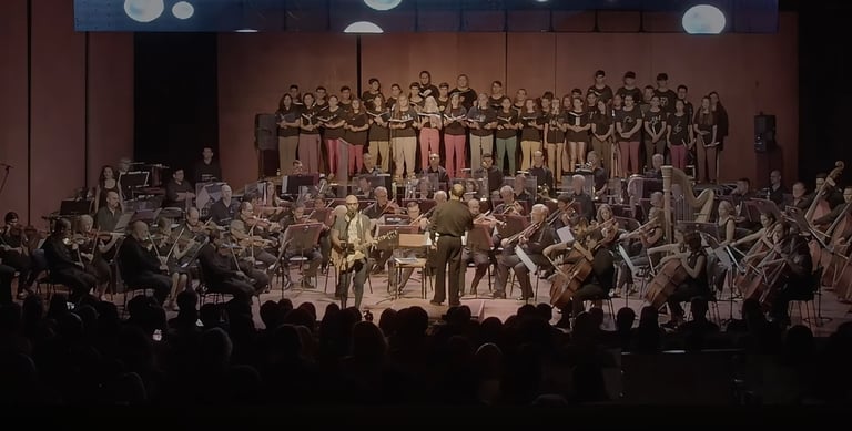 David De Mata with a conductor and orchestra in a concert hall