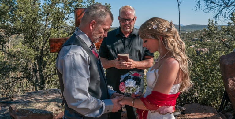 a man and woman getting married in a mountaintop