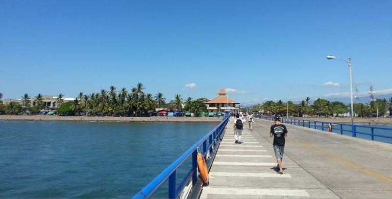 Vista do navio ancorado em Puntarenas, Costa Rica, com pier e cidade ao fundo