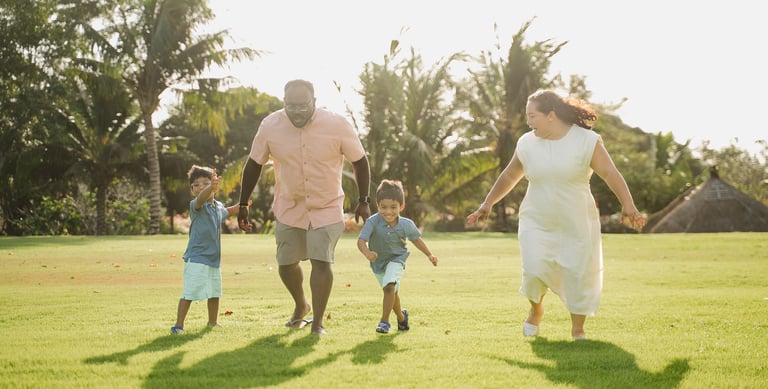 parents walking with their children on the lawn at rimba by ayana bali during family photography