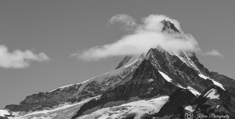 a mountain peak with a cloud in the background