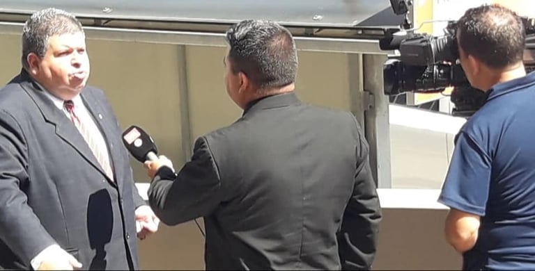 a man in a suit and tie is holding a microphone