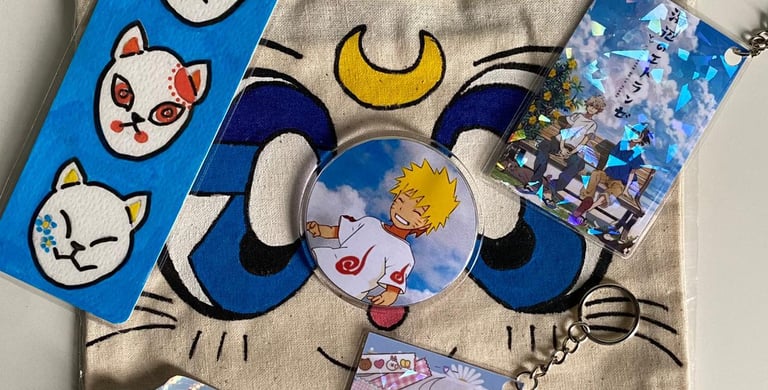 merchandising de anime, una tote bag de Sailor Moon, un llavero y pin de Naruto y stickers de H&H