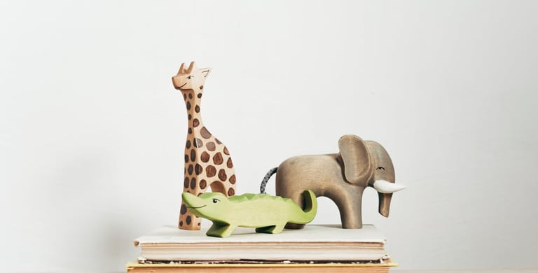 Toy wooden animals on stacked books