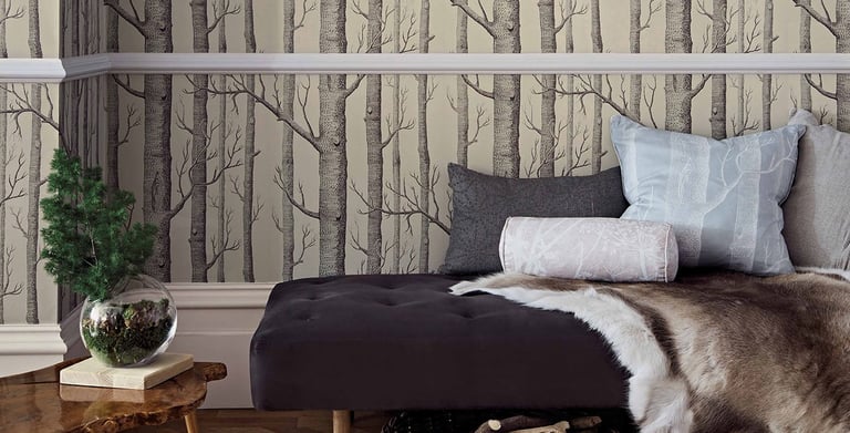 Rustic room featuring birch tree forest wallpaper with a daybed, fur rug, and gold deer head wall decor.