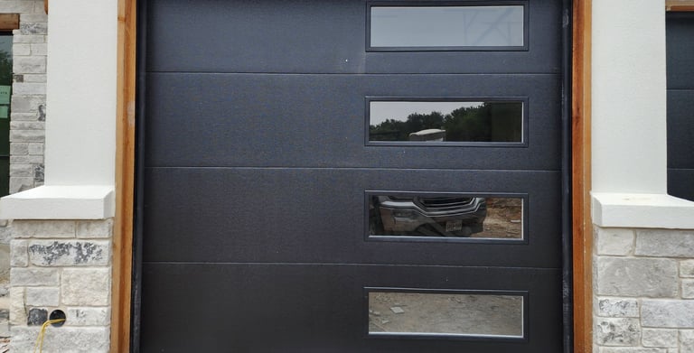 Black flush style with windows on the right installed by On point Overhead doors in Buda TX