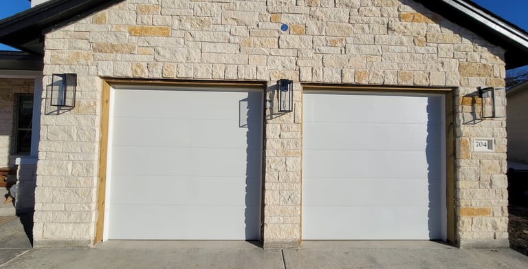 White Flush style garage doors installed by On Point Overhead Doors in Manor TX