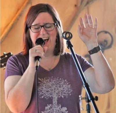 Speech Pathologist, Joy Walsh, singing into a microphone