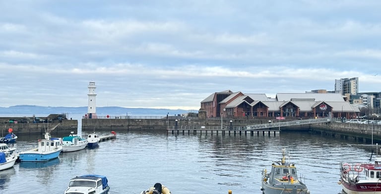 a group of boats in Newhaven harbour at the pier
