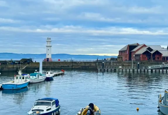 a group of boats in Newhaven harbour at the pier