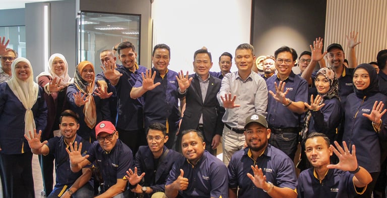a group of people standing around a man in a blue shirt