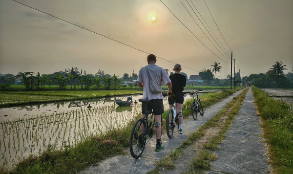 a group of people riding bikes down a village path