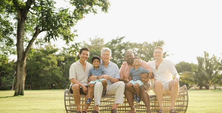 three generation family sitting together on rattan lounge chairs at rimba by ayana bali during sunset bali family photography