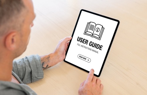 a man holding a tablet with a user's guide 