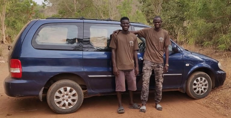 Twee gidsen van Birding Adventures Gambia & Senegal naast een blauwe minibus, gebruikt voor comforta