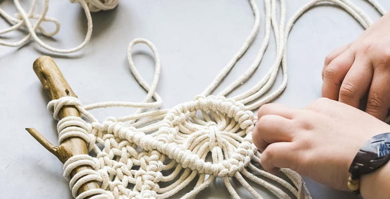 macrame blanco en vara de madera sobre mesa blanca
