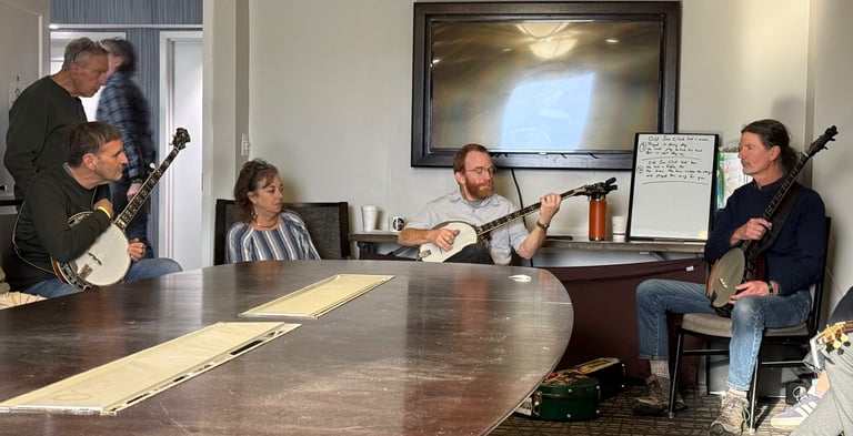 Mark Delaney holding a banjo while teaching a banjo workshop