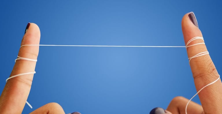 a person's fingers wrapped with a string of dental floss