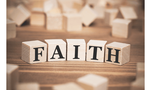 Wooden alphabet blocks spelling the word FAITH on a rustic brown surface.