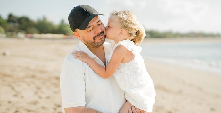 Father holding his daughter during a sunset family photography session at Ayodya Resort Bali in Nusa Dua
