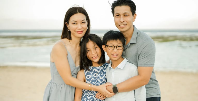 Family portrait by the ocean during a luxury family photography session at The Ritz-Carlton Bali.