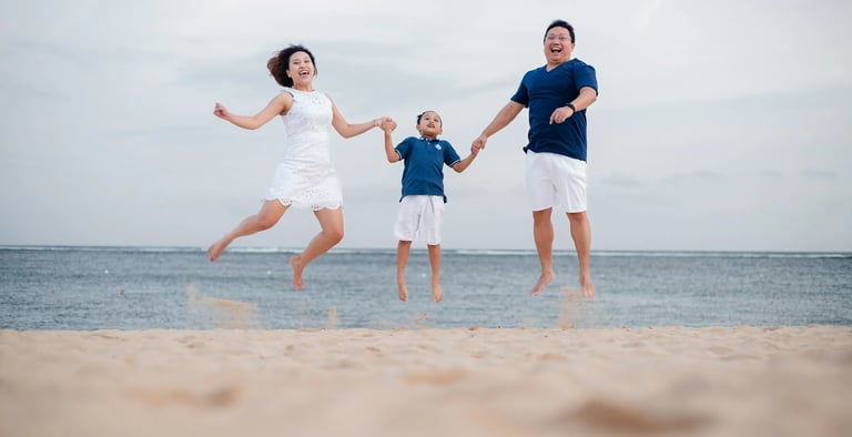 Family jumping together on the beach at The Mulia Nusa Dua Bali