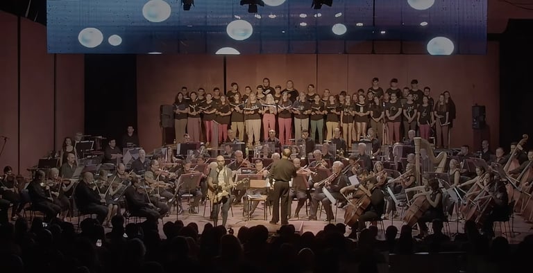 David De Mata with a conductor and orchestra in a concert hall