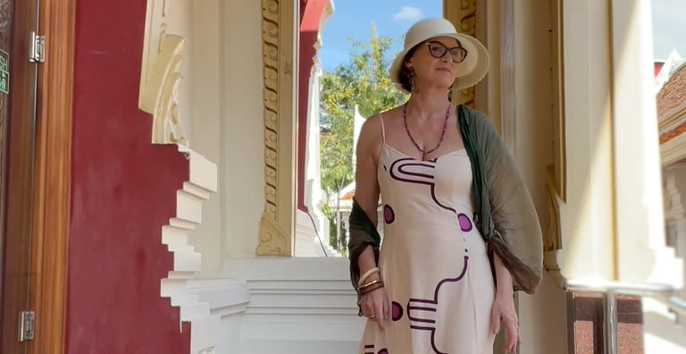 Deb Guy, embodiment mentor, standing on temple steps in a long white dress, representing feminine po