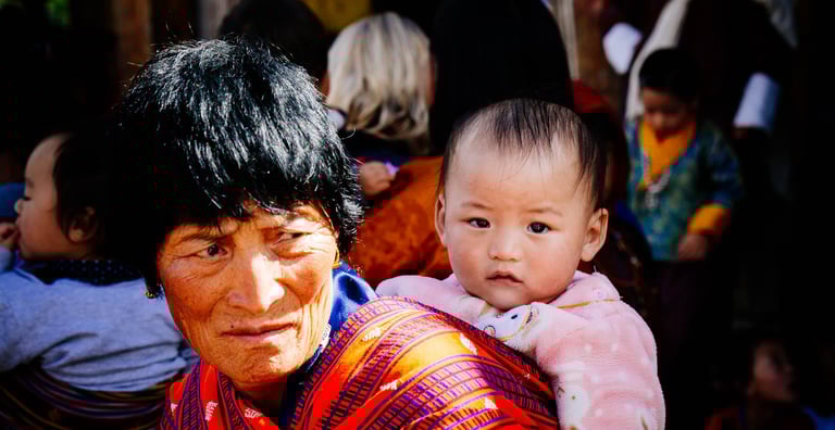 typical-bhutanese-women-carrying-her-new-born-at-her-back-held-with-traditional-hand-woven-fabrics