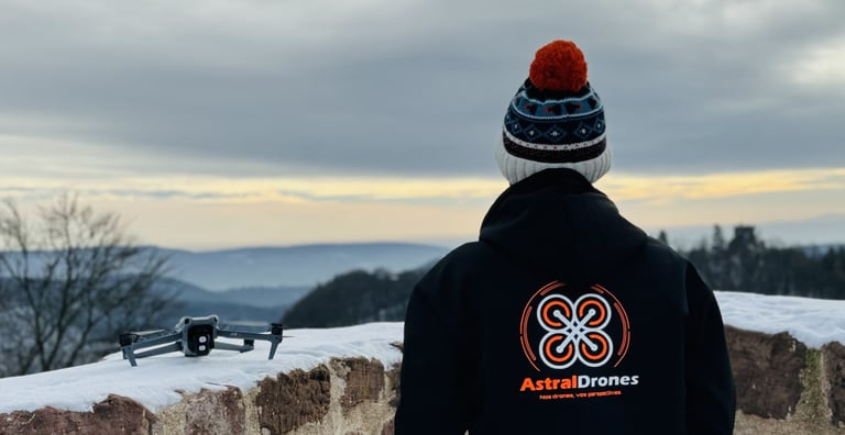 Télépilote Astral Drones avec un drone DJI Air 3 dans un paysage enneigé