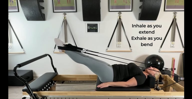 a woman working with the straps with her legs on the reformer
