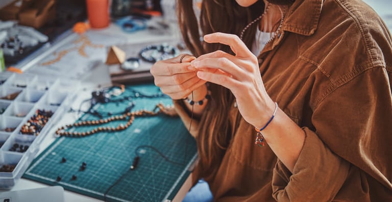Una joyera concentrada utiliza herramientas manuales especializadas para crear joyería personalizada