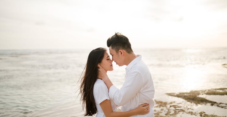 Couple embracing during golden hour proposal session at Melasti Beach Bali