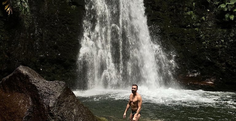 Gay man in waterfall at azores queer retreat
