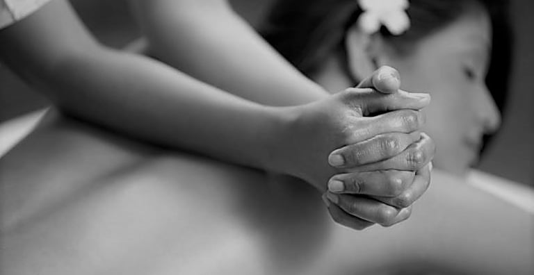 Une personne se fait masser le dos - massage appuyé, musculaire