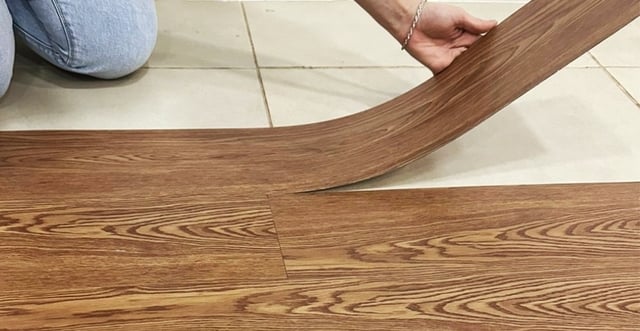homem com uma régua de piso vinílico fazendo a instalação sobre piso frio