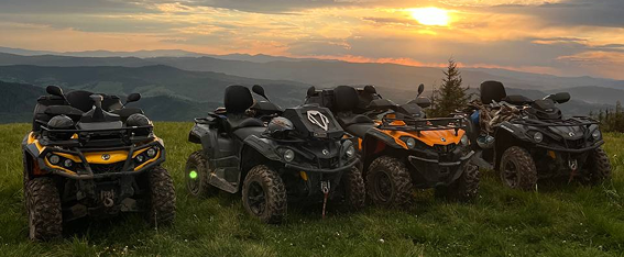 a group of four wheeler quad atvs parked on a grassy hill