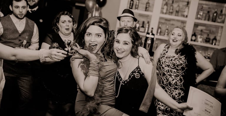 1920s themed murder mystery party. Lots of people are dressed up in a bar.