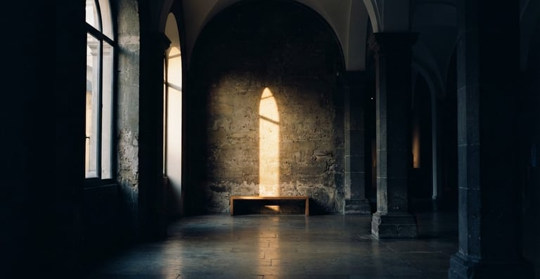 Cinematic low-key photography of a quiet, empty architectural space with soft golden-hour light cutting through deep shadows, 35mm film grain, elegant and contemplative