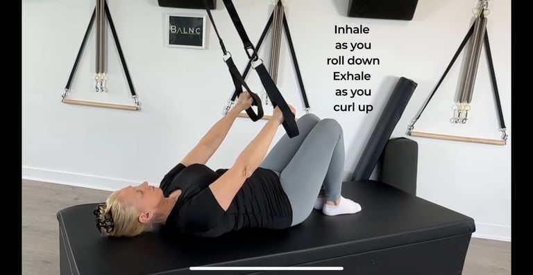 a woman pressing down on a suspension trainer with her arms