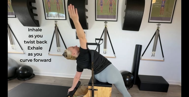 a woman stretching to the side with the Pilates Chair