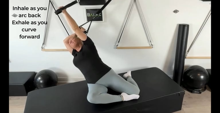 a woman hanging laterally in spine extension using a suspension trainer