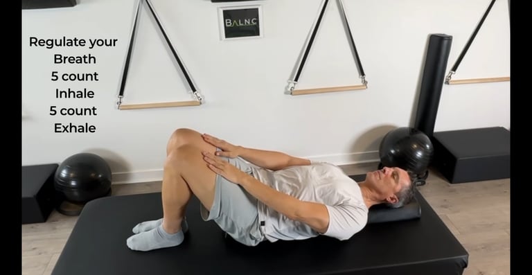 a man laying on a half roller to release tension in his spine