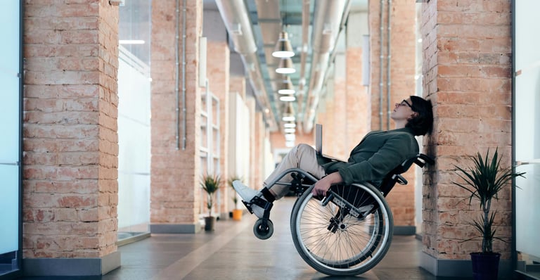 A wheelchair user rocking a wheeling in a corporate hallway