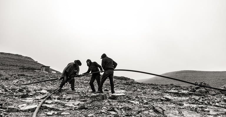 a group of men working on a rocky mountain