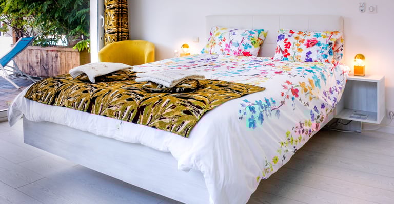 Bed with full bedding, floating bed with two with swimming pool in flower colours at Domaine Des Lucques