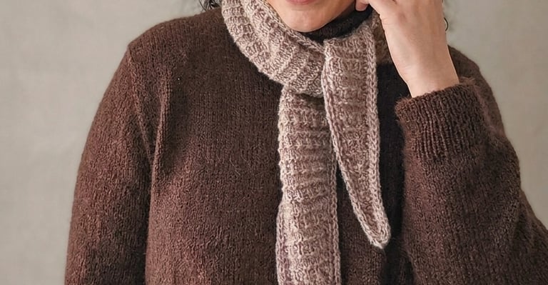 Woman wearing a chocolate brown sweater and a cosy beige scarf
